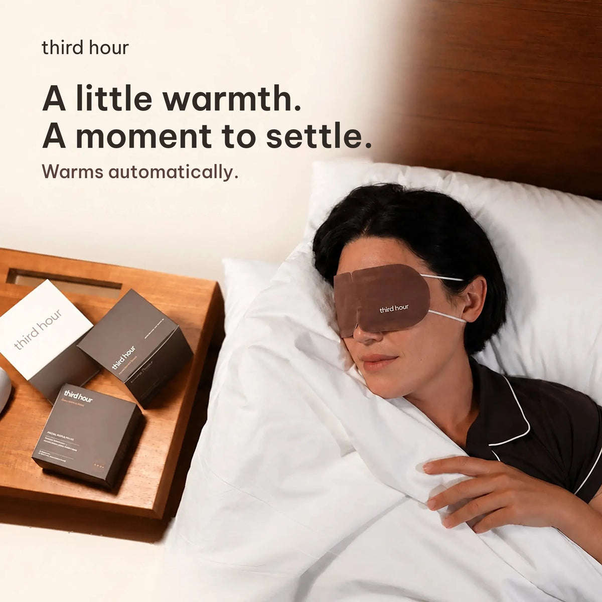 A little warmth. A moment to settle. Third Hour sleep mask warms automatically, worn in bed beside the bedside table.