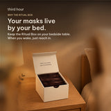 The Third Hour Ritual Box open on a bedside table, filled with warming sleep masks. Your masks live by your bed.